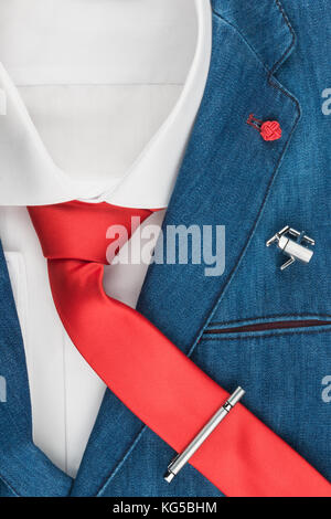 La moda maschile. Elegante giacca in denim con una cravatta rossa. Camicia maschile con cravatta e gemelli, clip, close-up Foto Stock
