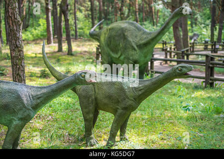 Solec kujawski, Polonia - Agosto 2017 : piccoli diplodocus dinosauri statue in una foresta Foto Stock