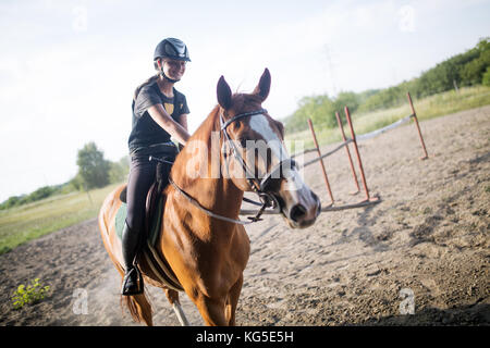 Ritratto di giovane donna di equitazione in campagna Foto Stock