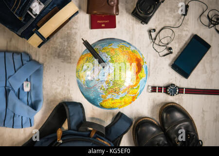 Concetto di viaggio. globe, passaporto, vestiti, telefono denaro per la preparazione di un viaggio Foto Stock