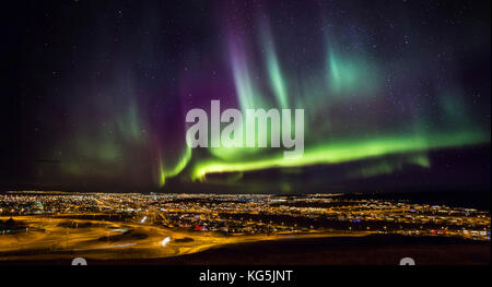 Aurora Borealis su Hafnarfjordur e Reykjavik, Islanda Foto Stock