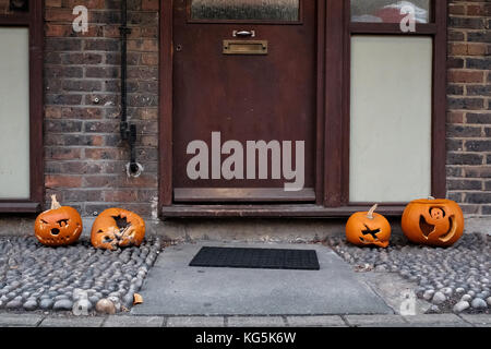 Una mostra spooky di zucche intagliate è visto schiacciato e danneggiato fuori di un appartamento a Hackney, Londra alcuni giorni dopo Halloween nel 2017. Foto Stock