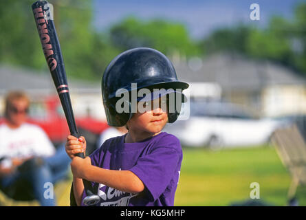 Una giovane ragazza giocando Little League Baseball, attende un passo dal lanciatore. Foto Stock