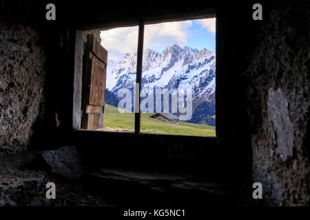 Vista dei prati verdi all'alba dalla capanna abbandonata in pietra Tombal Soglio Bregaglia Valle cantone di Graubünden Svizzera Europa Foto Stock