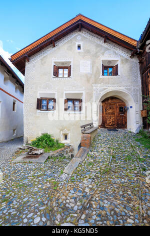 Tipica casa alpina incorniciata dal cielo blu in primavera Guarda Cantone di Graubünden Inn Distretto bassa Engadina Svizzera Europa Foto Stock