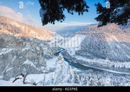 Transito del treno Rosso nella profonda gola del Reno. Gola del Reno (Ruinaulta), Flims, Imboden, Graubunden, Svizzera, Europa Foto Stock