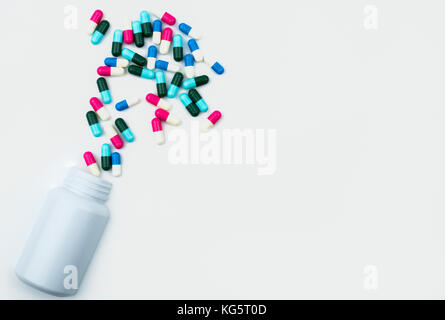 Versando antibiotici pillole di capsule in bottiglia di plastica isolati su sfondo bianco con copia di uno spazio di archiviazione di farmaco, il farmaco antibiotico utilizzare con ragionevole, Foto Stock