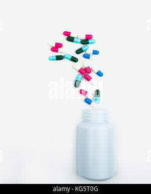 Versando antibiotici pillole di capsule in bottiglia di plastica isolati su sfondo bianco con copia di uno spazio di archiviazione di farmaco, il farmaco antibiotico utilizzare con ragionevole, Foto Stock