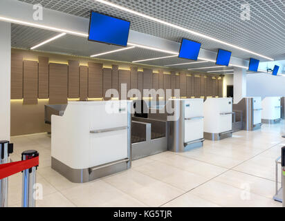 Svuotare i banchi check-in con computer e linee di attesa nella parte anteriore in aeroporto Foto Stock