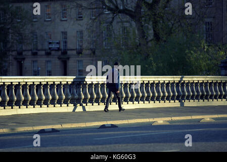 Adolescente incappucciati camminare da solo bassa sera sun prospettiva vista da dietro Foto Stock