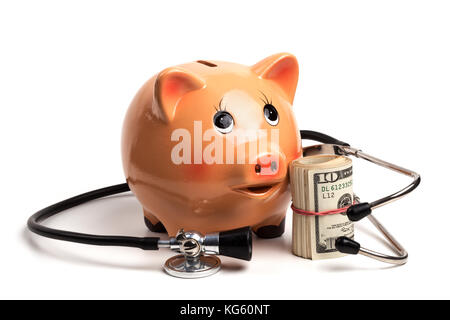 Carino salvadanaio con il nero lo stetoscopio e il dollaro banconote roll isolati su sfondo bianco Foto Stock