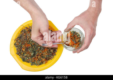 Un uomo anziano cucchiai una miscela secca di tè medicinali bosco e prato di piante in un bicchiere di vetro isolato su bianco studio shot Foto Stock