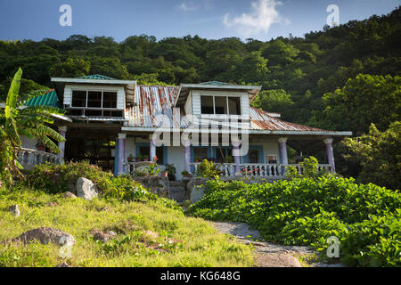 La Seychelles, Praslin, Petit Anse, Tradizionale stile bungalow con veranda in giardino sovradimensionate Foto Stock