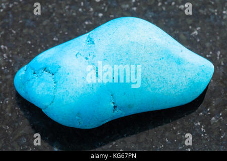 Le riprese in modalità macro di minerale naturale campione di roccia - lucidato turquenite (blu) howlite pietra in granito scuro dello sfondo Foto Stock