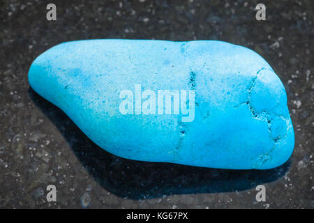 Le riprese in modalità macro di minerale naturale campione di roccia - burattati turquenite (blu) howlite pietra in granito scuro dello sfondo Foto Stock