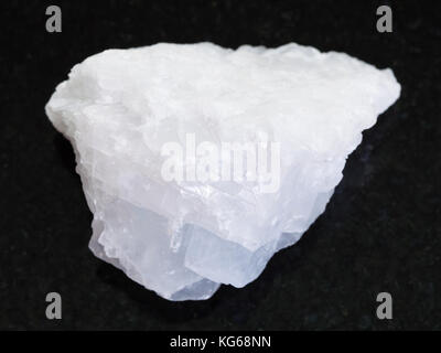 Le riprese in modalità macro di minerale naturale campione di roccia - cristallino grezzo magnesite sulla pietra di granito scuro dello sfondo Foto Stock