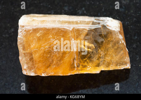 Le riprese in modalità macro di minerale naturale campione di roccia - tè ruvida calcite sulla pietra di granito scuro sfondo dal Messico Foto Stock