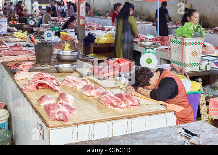 Lijiang, Yunnan, Cina - 27 Settembre 2017: fornitore di appoggio al mercato locale. La Cina consuma circa il 28% di tutto il mondo di carne, metà si tratta di carne di maiale. Foto Stock