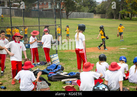 Partita di softball delle ragazze scolastiche australiane a Sydney, Australia, con studenti che indossano l'uniforme sportiva scolastica Foto Stock