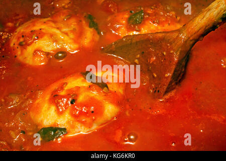 Balti cottura del pollo e viene agitato con un cucchiaio di legno Foto Stock