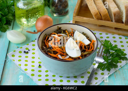 Antipasti fatti in casa su una festa di natale nella tabella. con insalata di uova, coreano le carote e il cavolo riccio di mare. Foto Stock