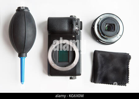 Fotocamera digitale con gli strumenti di pulizia su sfondo bianco Foto Stock