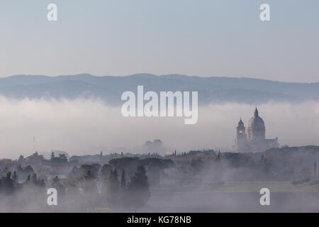 Vista su Santa Maria degli Angeli chiesa papale (Assisi), emergenti dalla nebbia Foto Stock