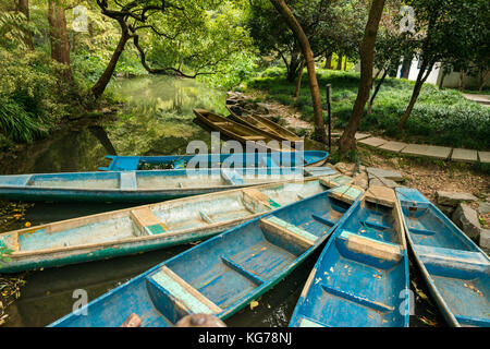 Barche blu tetheres a riverbank, sfondo, giorno all'aperto, naturale, vecchio Foto Stock