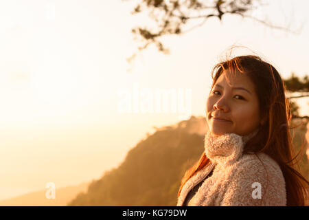 Closeup donna faccia sensazione di fresco con il sorgere del sole al mattino Foto Stock