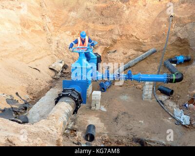 Città principale tubazione di alimentazione dell'acqua. Il personale tecnico del giubbotto metropolitana tubazione di comando gate. Riparato sistema di pipeline. Controllo finale Foto Stock
