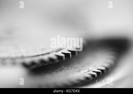 Ruote dentate, sfondo industriale monocromatico. Profondità di campo molto bassa, la messa a fuoco è molto piccola. Fotografia creativa per progetti concettuali. Macro. Foto Stock