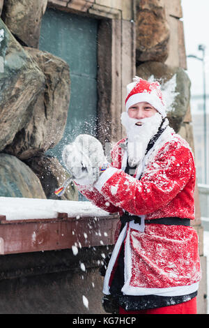 STOCCOLMA, SVEZIA – 11 DICEMBRE 2016: Giovane vestito da babbo natale che si prepara a lanciare una palla di neve, durante l'evento di beneficenza Stockholm Santa Run in Svezia Foto Stock
