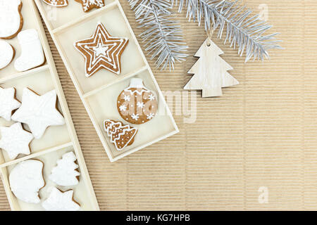 Confezioni regalo di Natale fatti in casa gingerbreads e argento ramo di abete con decorazioni su carta marrone sfondo Foto Stock