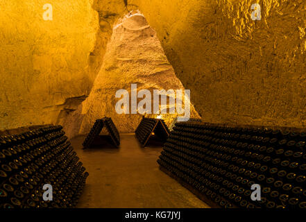 Reims, Francia - 12 giugno 2017: le grotte di casa di champagne taittinger con vecchie bottiglie di champagne pupitres, Francia. Foto Stock