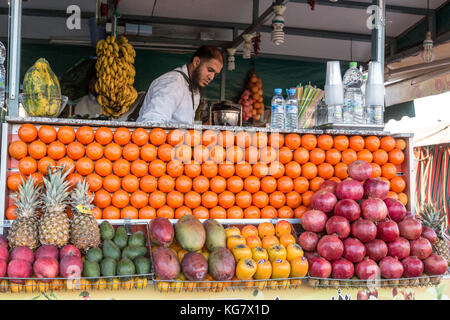 Marrakech, Marocco, ottobre 25, 2017: un uomo vendita di succo di frutta fresco in piazza Jamaa el Fna nella medina di Marrakesh. Foto Stock