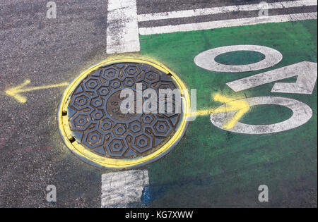 Coperchio di fognatura su new york city bike lane Foto Stock