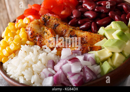 Burrito ciotola con pollo alla griglia, riso e verdure vicino sul tavolo. orizzontale, in stile messicano Foto Stock