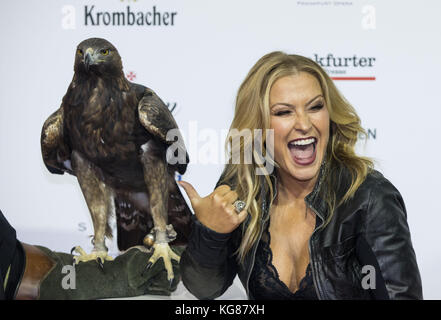 La cantante Anastacia posa con il falco "Attila", la mascotte della squadra di calcio Eintracht Frankfurt, durante l'arrivo al 36° German Sports Press Ball ("36. Deutscher Sportpresseball") presso la Old Opera di Francoforte sul meno, Germania, 4 novembre 2017. Foto: Frank Rumpenhorst/dpa Foto Stock