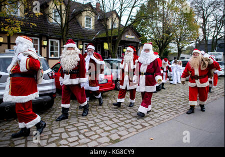 Celle, Germania. 4 novembre 2017. Numerosi imitatori di Babbo Natale e Angelo di Natale possono essere visti in strada a Garssen, un quartiere di celle, Germania, il 4 novembre 2017. Da più di dieci anni, il sosia di Babbo Natale, Willi Dahmen, offre un corso di formazione per gli impersonatori di Babbo Natale e Angelo di Natale. I partecipanti impareranno anche a conoscere il codice onorario degli imitatori di Babbo Natale. Crediti: Hauke-Christian Dittrich/dpa/Alamy Live News Foto Stock