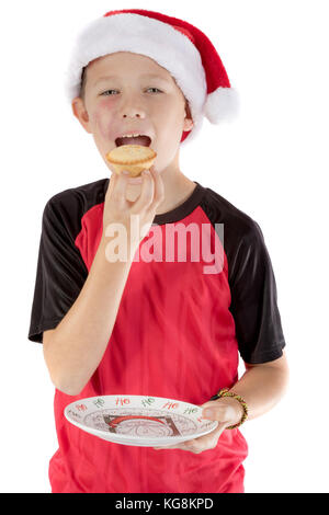 Pre-teen boy nel cappello di Natale e un pasticcio di carne macinata Foto Stock