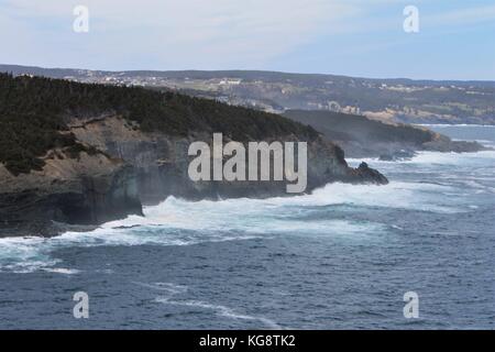 Onde che si infrangono contro gli scogli, Logia Bay-Middle Cove-Outer Cove, Terranova e Labrador, Canada. La nebbia leggera, blu cielo e acqua, white surf. Foto Stock