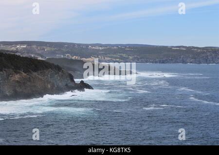 Onde che si infrangono contro gli scogli, Logia Bay-Middle Cove-Outer Cove, Terranova e Labrador, Canada. La nebbia leggera, blu cielo e acqua, white surf. Foto Stock