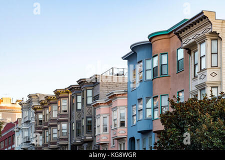 La luce del tramonto brilla su una fila di edifici colorati su nocciola Street di San Francisco, California Foto Stock