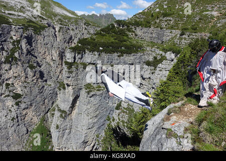 Questo Wingsuit ponticello di base appena scavalcato il ciglio della scogliera e brave diving giù nell'incerto. Ben presto egli deve aprire il suo paracadute da salvare. Foto Stock