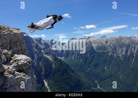 Questo Wingsuit ponticello di base appena scavalcato il ciglio della scogliera e brave diving giù nell'incerto. Ben presto egli deve aprire il suo paracadute da salvare. Foto Stock