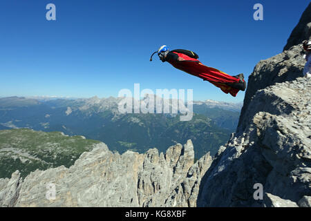 Questo Wingsuit ponticello di base appena scavalcato il ciglio della scogliera e brave diving giù nell'incerto. Ben presto egli deve aprire il suo paracadute da salvare. Foto Stock