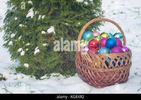 Natale colorati-tree giocattoli in un cestello di vintage sulla neve. tonica. Foto Stock