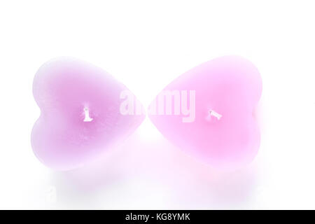 Due candele colorate su sfondo bianco. Foto Stock