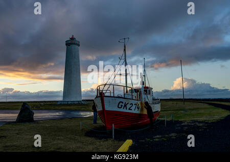 Faro e barca sulla penisola di Reykjanes a Reykjavik, ghiaccio Foto Stock