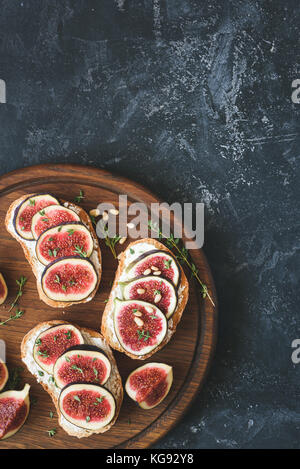 Fig e antipasto di formaggio di pane tostato Bruschetta o sul bordo di taglio. Vista da sopra con copia spazio per il testo Foto Stock